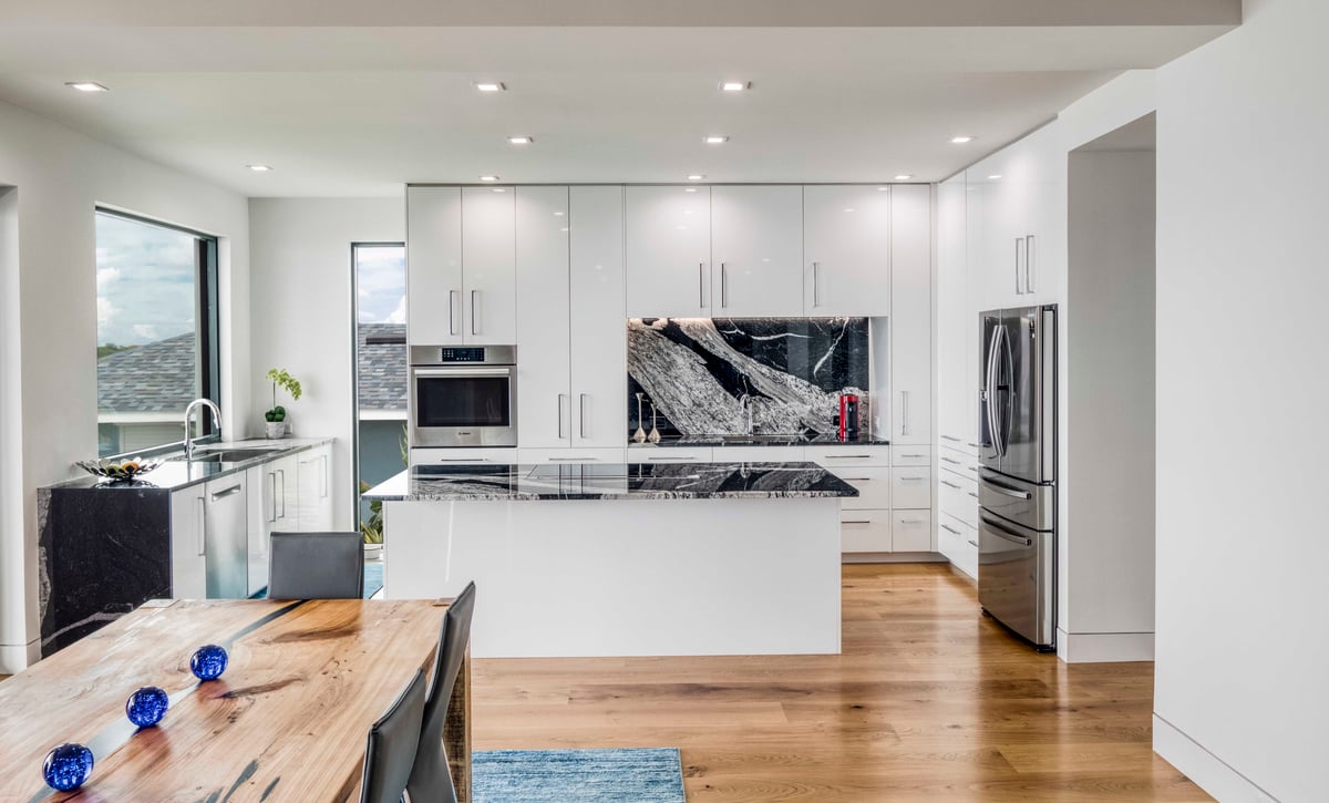 Modern white kitchen with high-gloss flat cabinets and wood plank flooring