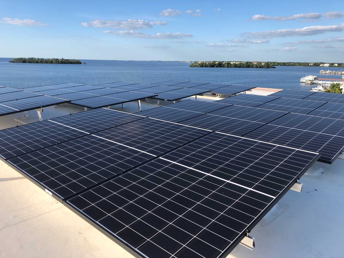 Image of solar panel array on roof of modern white home