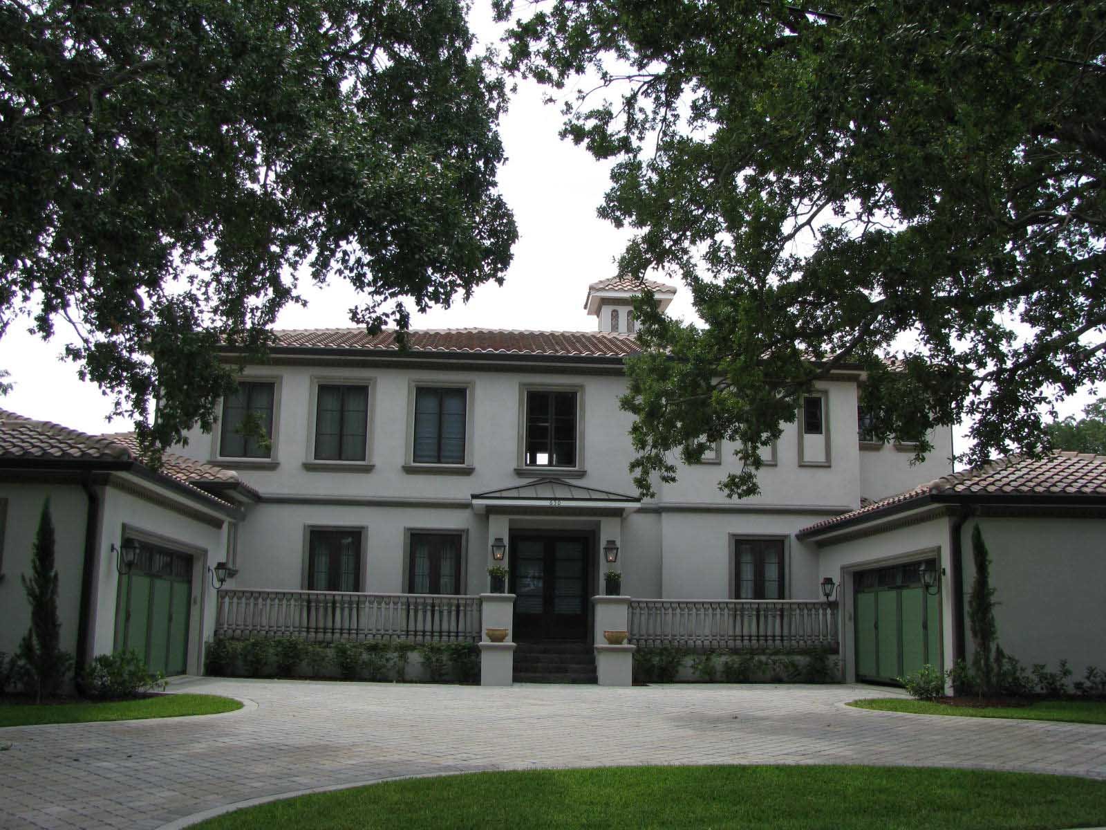 Image of beautiful white modern italianate home with dark bronze trim, red tile roof, and green garage doors