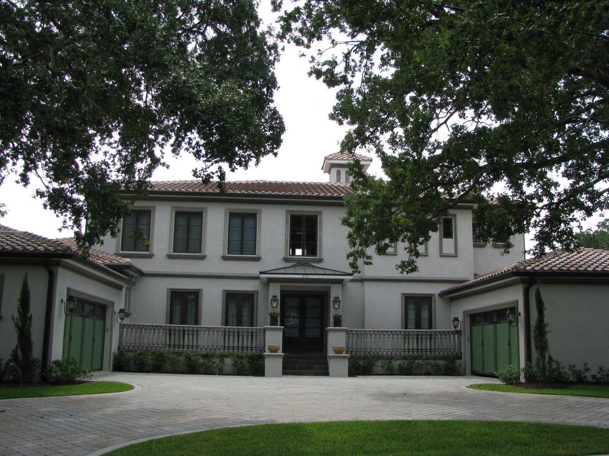 Image of beautiful white modern italianate home with dark bronze trim, red tile roof, and green garage doors
