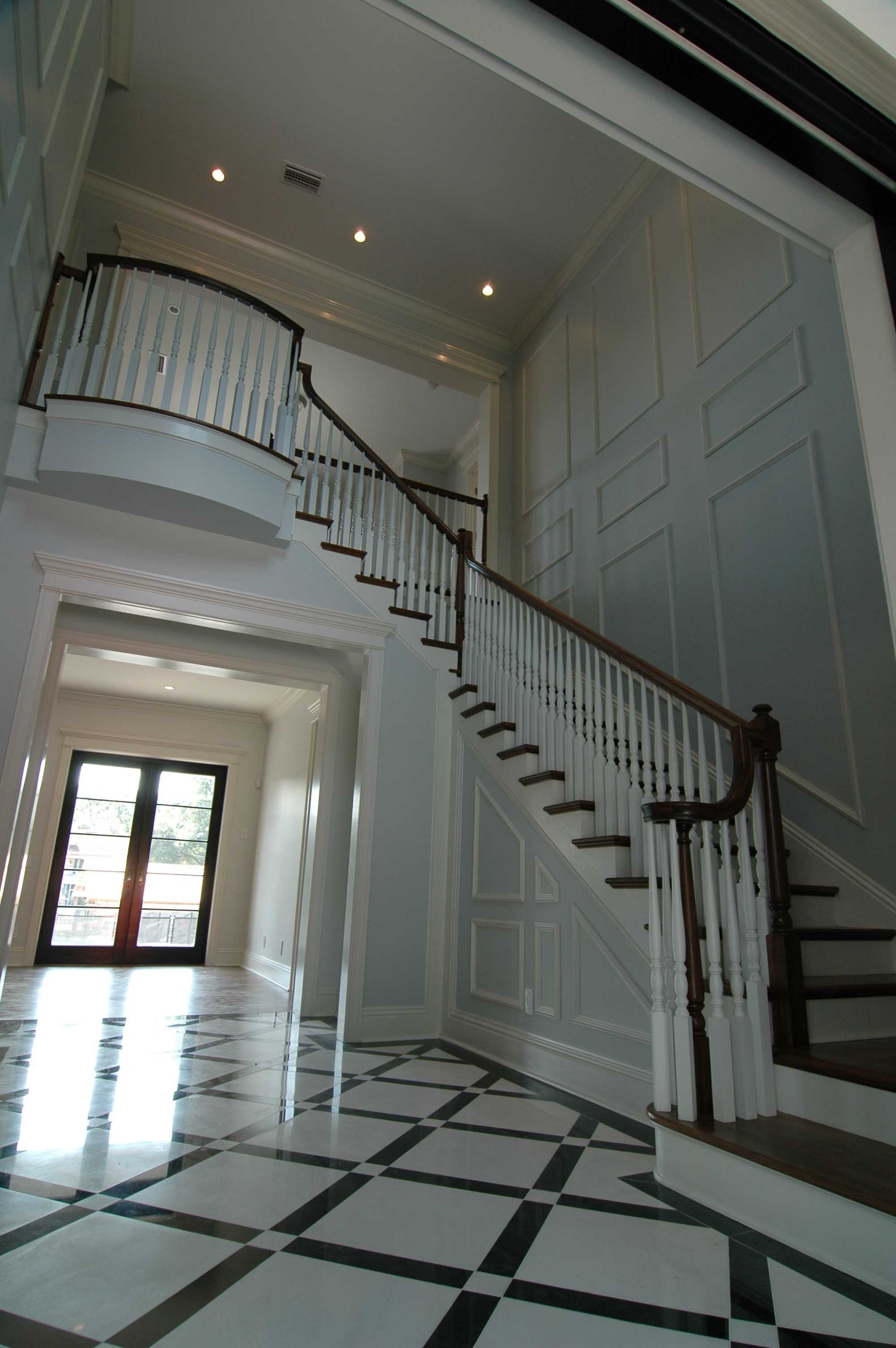 Image of two story stairs with ornate white spindles and dark brown wood banister