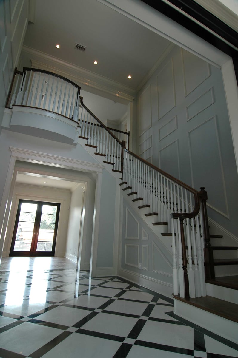 Image of two story stairs with ornate white spindles and dark brown wood banister
