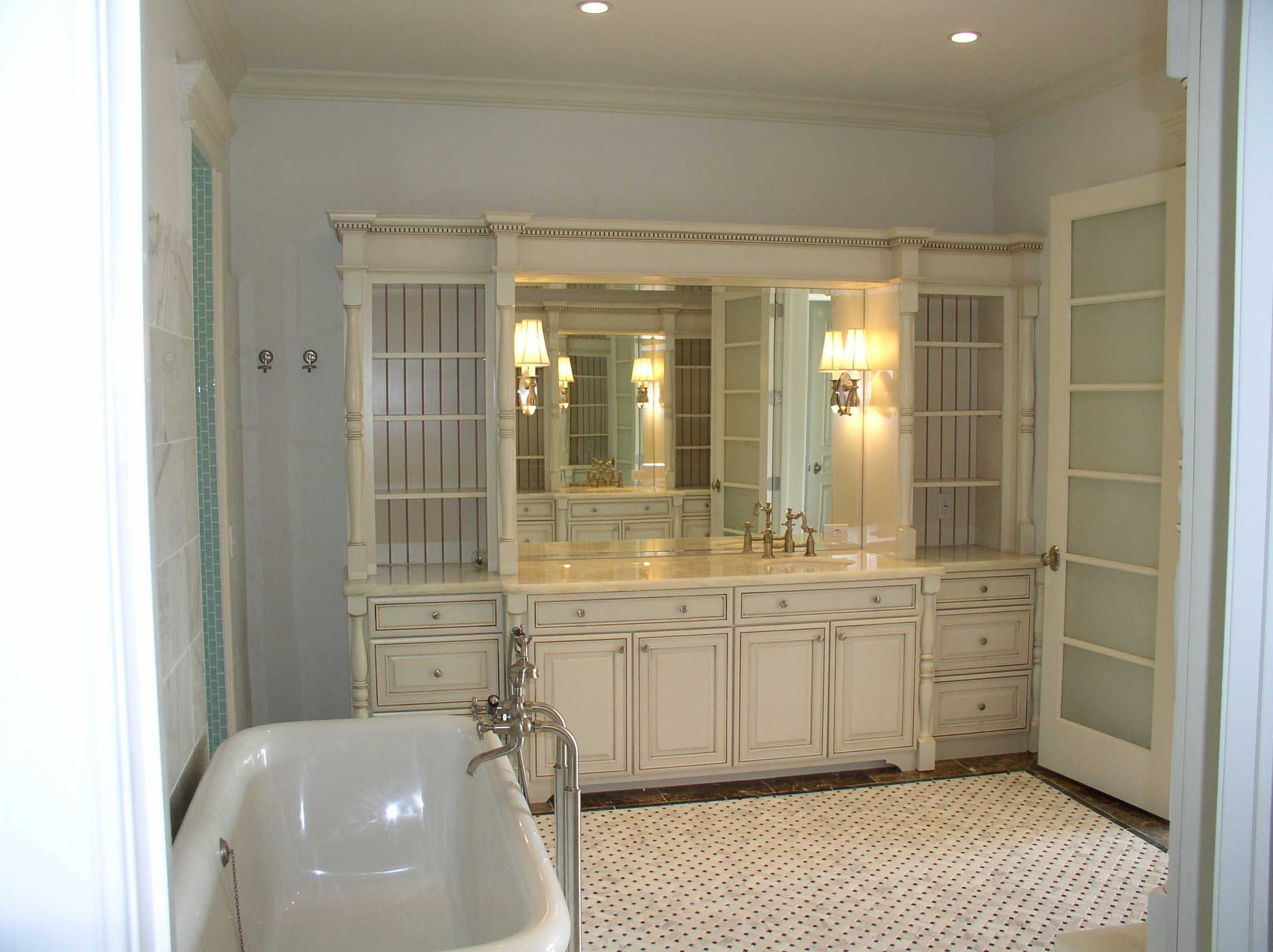 Image of large bathroom with curved wall bathtub, large furniture styled vanity and storage, and detailed tile floor pattern
