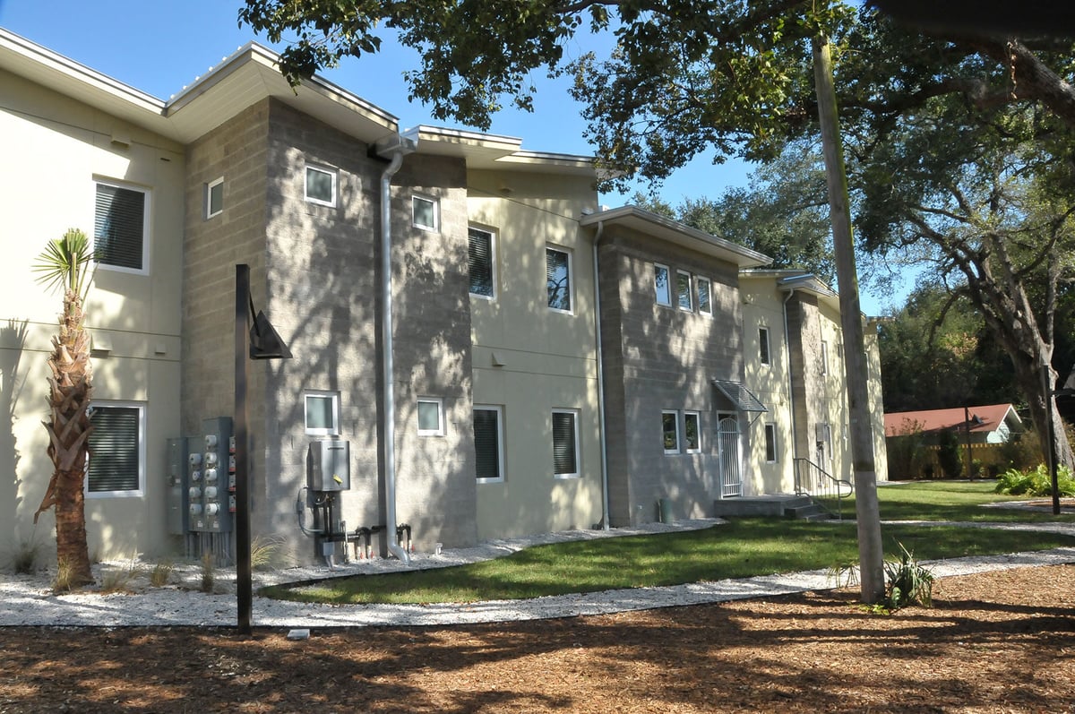 Image of side view of multi-story eco friendly designed apartment complex with angled roofs